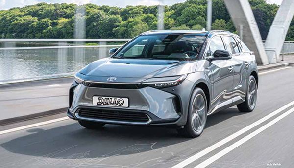 Silberner Toyota bZ4X Elektro, Frontansicht, fahrend über Brücke in grüner Umgebung
