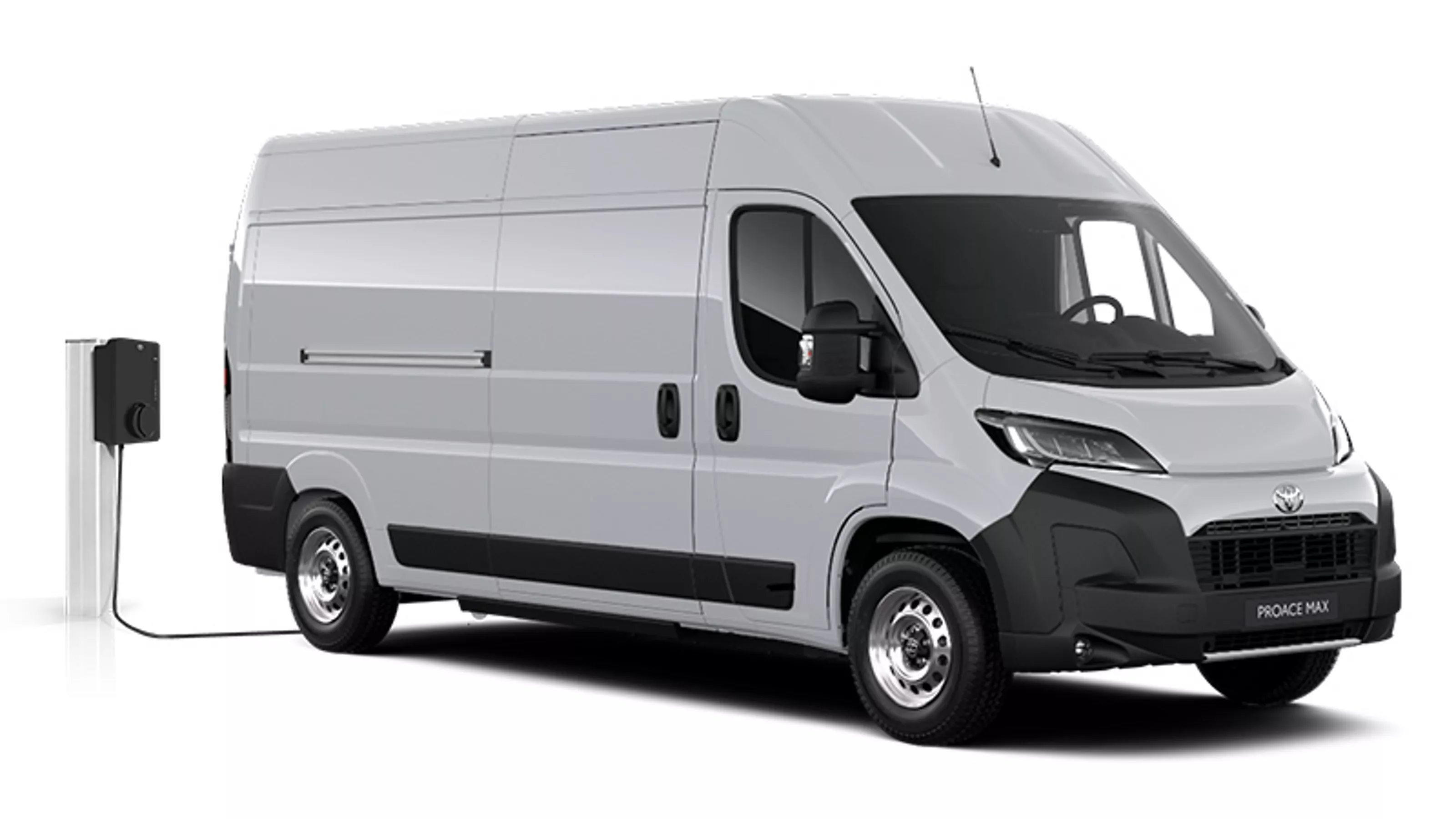 Ein weißer Toyota Proace Max Electric Meister in diagonaler Frontansicht vor einem weißen Hintergrund neben einer Ladesäule.